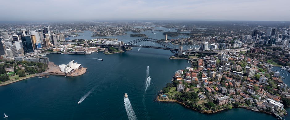 Stunning aerial view capturing Sydney Opera House and Harbour Bridge in daylight.